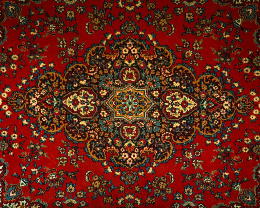 Detail of a red rug with a multicolored pattern