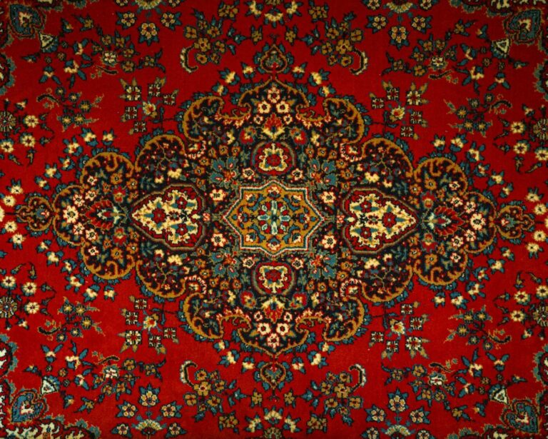 Detail of a red rug with a multicolored pattern