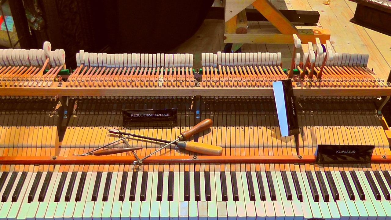 Open piano with the keyboard exposed and tuning tools resting on the action