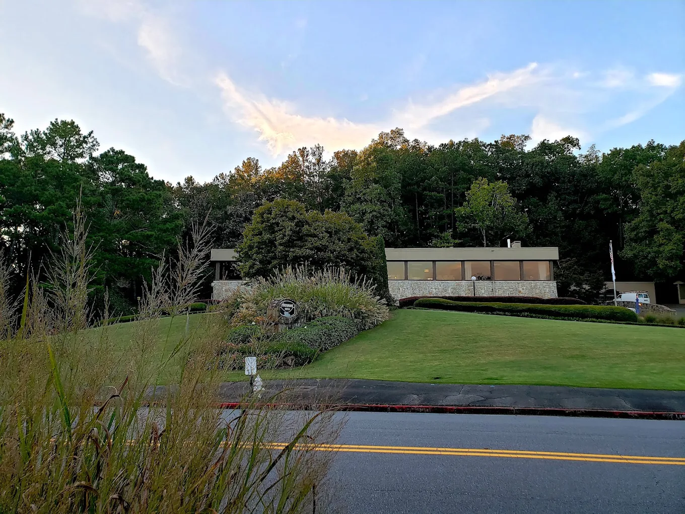 Rivermont Country Club building behind a manicured lawn and trees