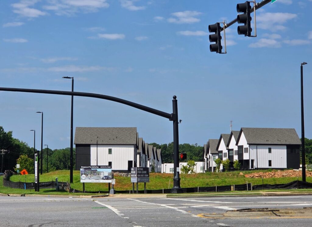 Retail buildings under construction behind a Shoppes at The Gathering sign.