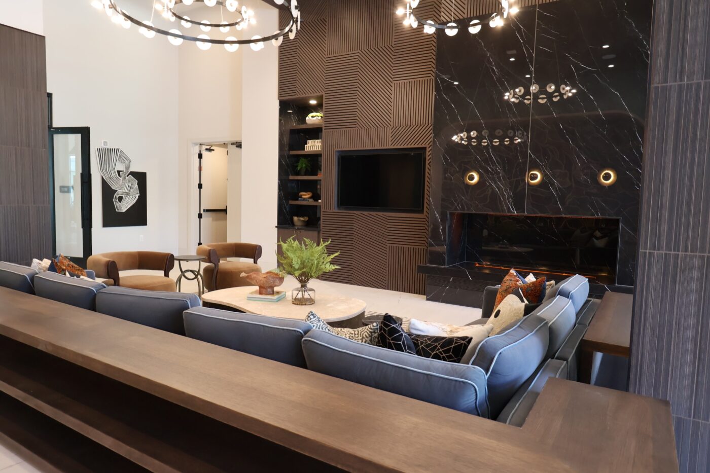 Sofas and chairs arranged around a fireplace and television in a Prelude lounge.