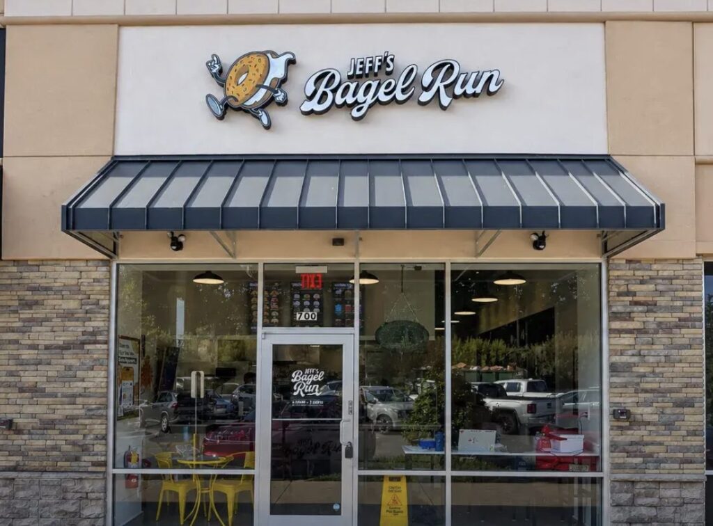 Exterior of Jeff’s Bagel Run storefront with a black awning and large sign above the entrance