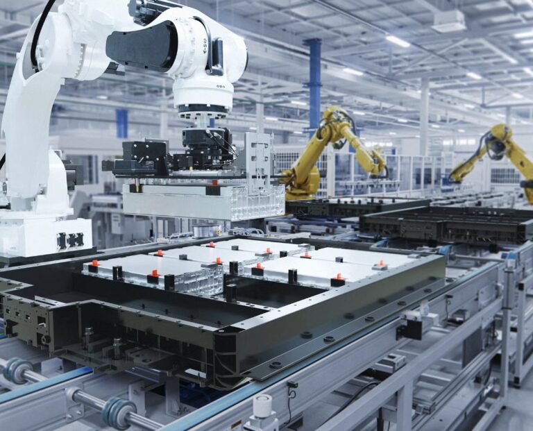 Automated robotic arms working over a manufacturing assembly line in a bright factory.